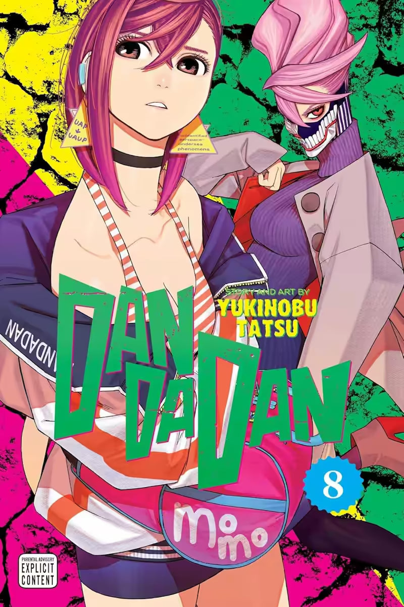 Manga forside til ‘Dandadan’ bind 8, der viser en ung kvinde med pink hår og trekantede øreringe forrest, iført en sporty top og jakke, mens en anden kvinde med maske og høj, formet frisure står bag hende mod en grøn og gul baggrund.